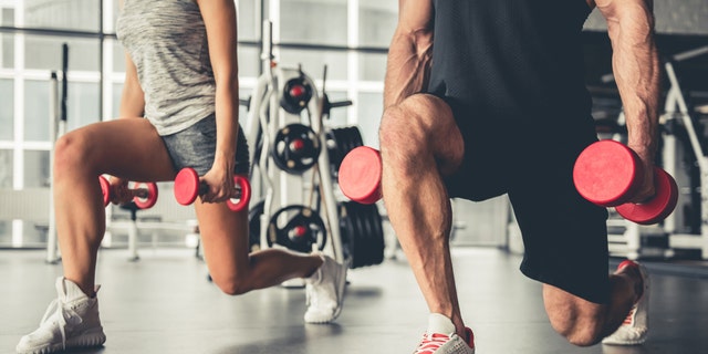 People lifting weights at a gym. 