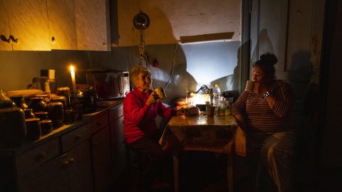 Natalia Zemko, 81, talks with her daughter Lesya as they drink tea in their kitchen during a power outage in downtown Kyiv on October 22.