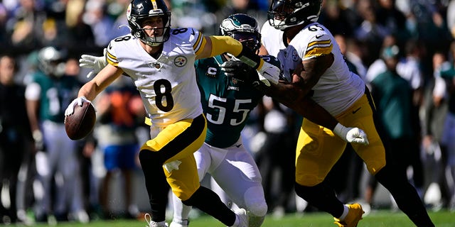 Pittsburgh Steelers quarterback Kenny Pickett, #8, evades a tackle by Philadelphia Eagles defensive end Brandon Graham, #55, during the first half of an NFL football game between the Pittsburgh Steelers and Philadelphia Eagles, Sunday, Oct. 30, 2022, in Philadelphia.