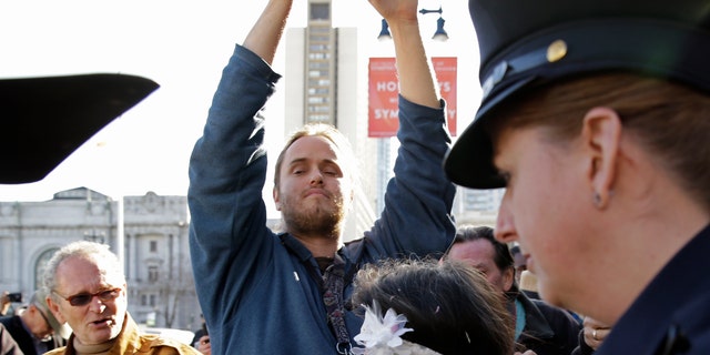 David DePape, center, records Gypsy Taub being led away by police after her nude wedding outside City Hall on Dec. 19, 2013, in San Francisco. 