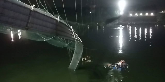 Rescuers on boats search in the Machchu river next to a cable bridge that collapsed in Morbi district, western Gujarat state, India, Sunday, Oct.30, 2022. 