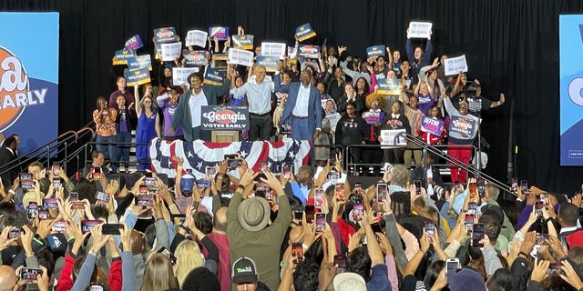 Former President Barack Obama, center, stands with Georgia gubernatorial candidate Stacey Abrams and candidate for U.S. Senate, Sen. Raphael Warnock D-Ga., during a campaign rally Friday, Oct. 28, 2022, in College Park, Ga. 