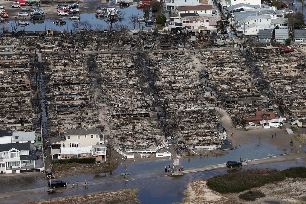 People gather around the remains of burned homes after Superstorm Sandy on Oct. 31, 2012 in the Breezy Point neighborhood.