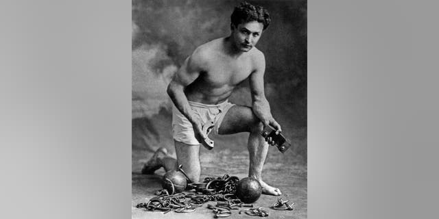 American conjuror Harry Houdini (1874-1926) here with chains, c. 1906. 