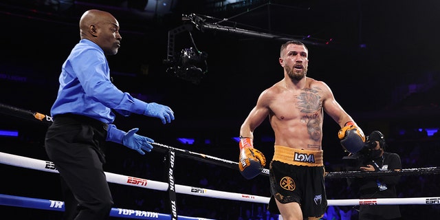 NEW YORK, NEW YORK - DECEMBER 11: Vasiliy Lomachenko, right, knocks-down Richard Commey, center, during their fight for the WBO intercontinental lightweight championship at Madison Square Garden on December 11, 2021 in New York City. 