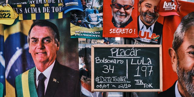 A man stands by a street stall selling towels of presidential candidates Luis Inacio Lula da Silva and Jair Bolsonaro at Paulista avenue on Sept. 23, 2022 in Sao Paulo, Brazil. The stall displays a sign with the number of towels of each candidate sold so far. Brazilians will go to polls on Oct. 2 in a polarized presidential election.