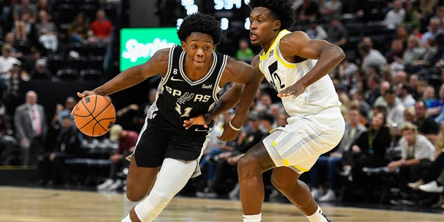 Joshua Primo #11 of the San Antonio Spurs drives into Collin Sexton, #2 of the Utah Jazz, during a game at Vivint Arena on October 11, 2022, in Salt Lake City, Utah. 