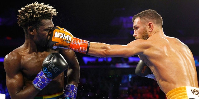 NEW YORK, NEW YORK - DECEMBER 11: Vasiliy Lomachenko (black trunks) trades punches with Richard Commey (blue trunks) at Madison Square Garden on December 11, 2021 in New York, New York. 