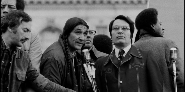 Jim Jones, center right, American cult leader and founder of the Peoples Temple, speaks during a rally in San Francisco on April 3, 1976.