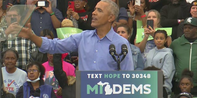 Former President Barack Obama reacts to being interrupted by a man during a Saturday rally in Michigan.