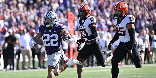 MANHATTAN, KS - OCTOBER 29:  Running back Deuce Vaughn #22 of the Kansas State Wildcats rushes for a touchdown past safety Thomas Harper #13 of the Oklahoma State Cowboys during the first half at Bill Snyder Family Football Stadium on October 29, 2022 in Manhattan, Kansas.