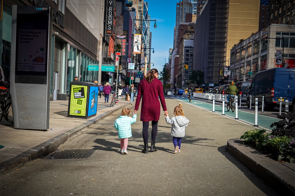 A woman and two children stand in the gravel expanded pedestrian zone