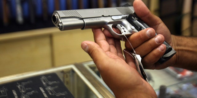 A man chooses a gun April 18, 2007, at the Gun Gallery in Glendale, California.