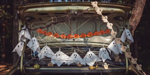 Trunk-or-treat candy distributors decorate their car trunks for Halloween trick-or-treaters.