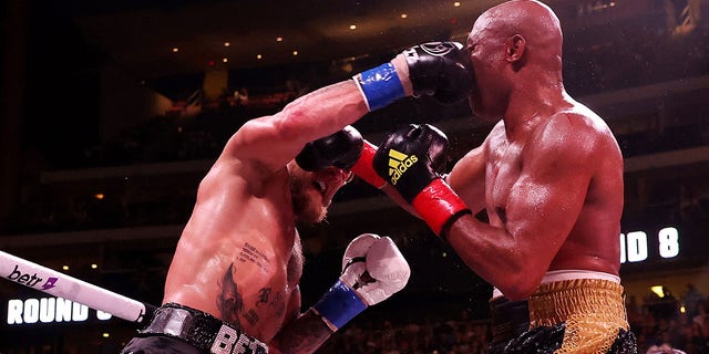 Jake Paul (L) exchanges strikes with Anderson Silva of Brazil during their cruiserweight bout at Gila River Arena on October 29, 2022 in Glendale, Arizona. 