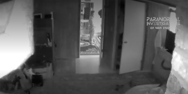 The PI-NE team said that the figure shown in the video — shown here, standing in front of a chair — is actually an apparition.