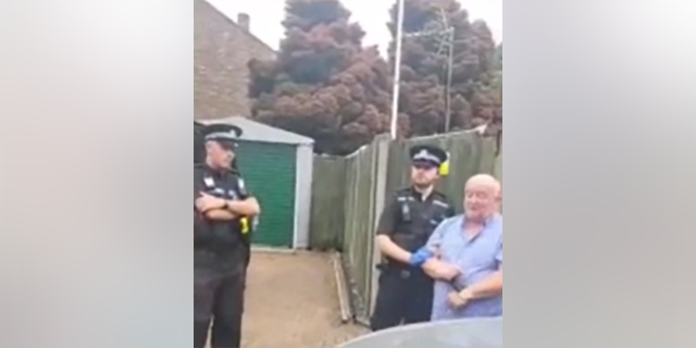 Hampshire police with Army veteran Darren Brady in handcuffs outside his home. 