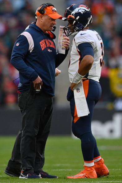 Broncos coach Nathaniel Hackett speaks with quarterback Russell Wilson during Sunday's game against the Jaguars.