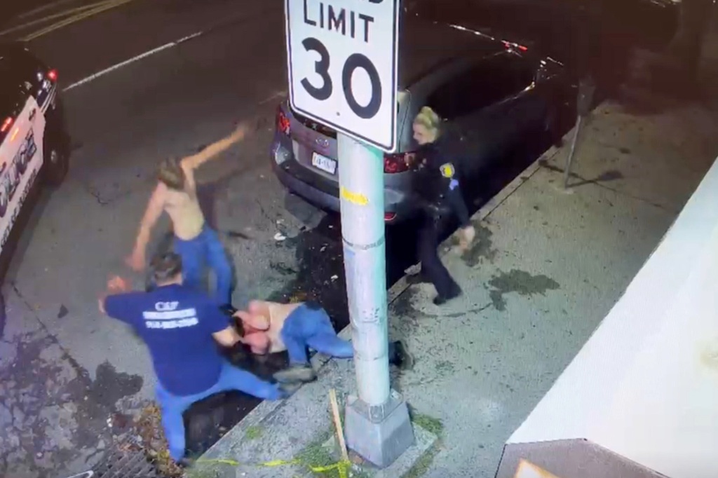 Two men are seen attacking a man as he is on the ground.