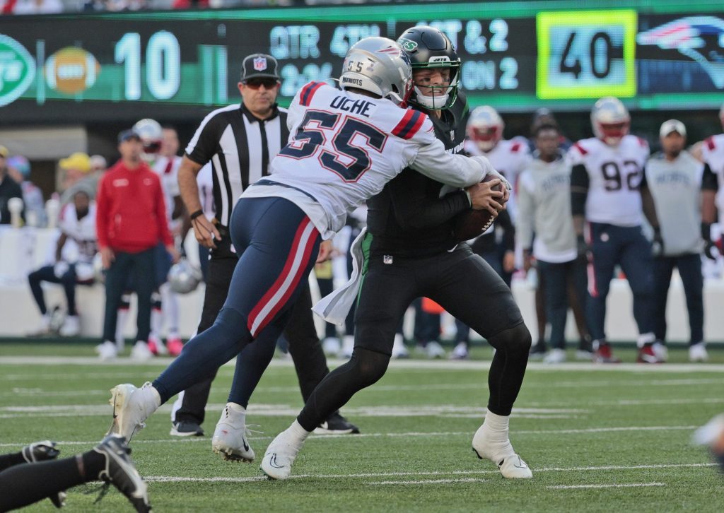 New York Jets quarterback Zach Wilson #2 gets sacked by New England Patriots linebacker Josh Uche #55 during the fourth quarter.