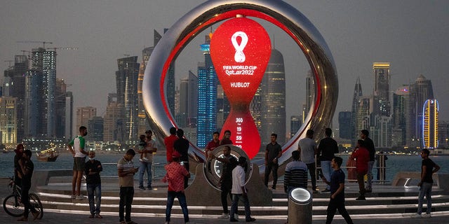 People gather around the official countdown clock showing remaining time until the kick-off of the World Cup 2022, in Doha, Qatar, Nov. 25, 2021.