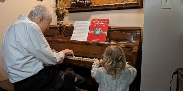 Harold Chilton played the piano for his birthday party guests, including his great-great-granddaughter Kit.