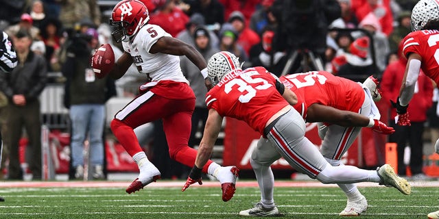 Dexter Williams II (5) of the Indiana Hoosiers attempts to outrun Tommy Eichenberg (35) and Michael Hall Jr. (51) of the Ohio State Buckeyes during the second quarter of a game at Ohio Stadium Nov. 12, 2022, in Columbus, Ohio.