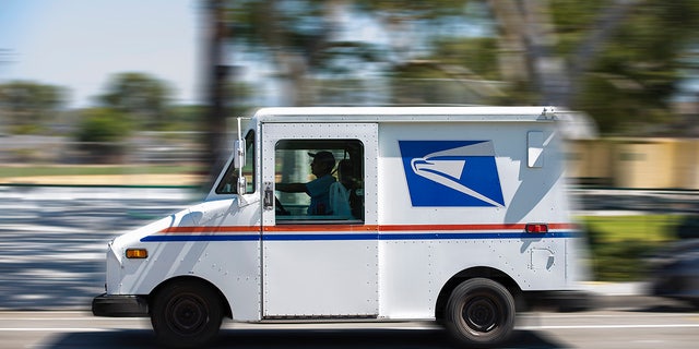 A USPS (United States Postal Service) mail truck leaves for a delivery in Fullerton, Califnoria, on July 18, 2020.